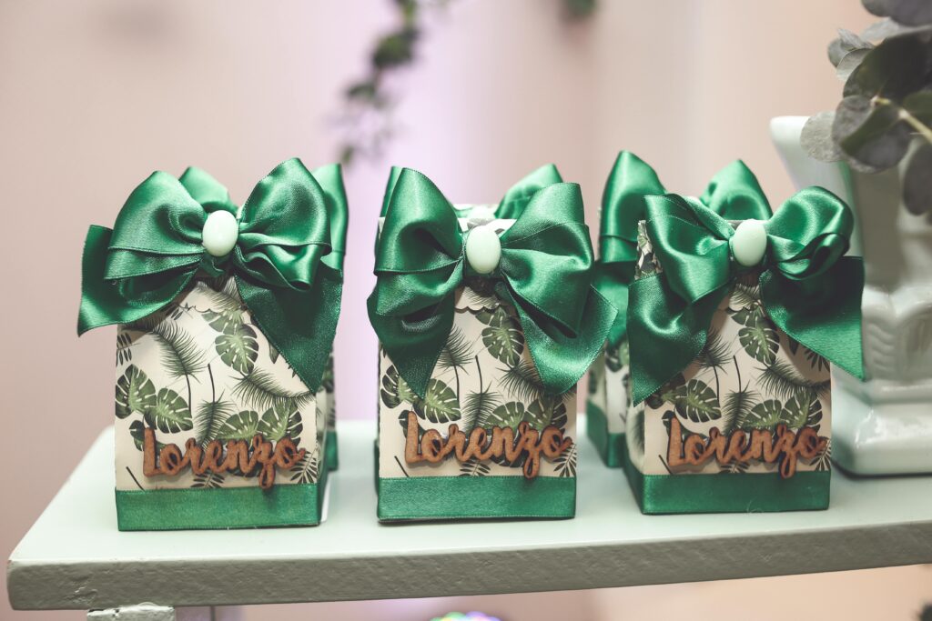 Set of decorated gift boxes with green bows and tropical leaf pattern, labeled 'Lorenzo'.