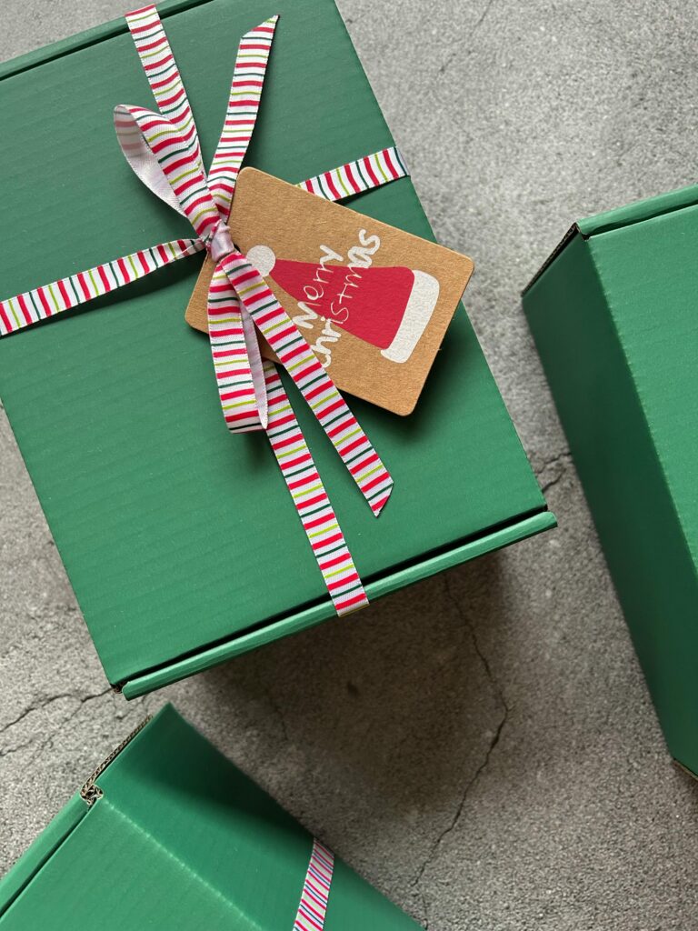 Festive green gift boxes adorned with striped ribbon and Merry Christmas tag.